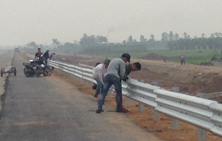 Nhà thầu “kêu cứu” vì liên tục bị mất trộm vật tư thi công đường cao tốc - 1 Các công nhân thi công lắp ráp tôn rào chắn trên đường cao tốc.