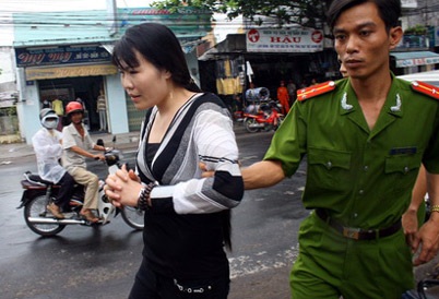 Bài 5: Bắt bà chủ xăm hình "quái vật" lên mặt và ngực thiếu nữ - 1 Nguyễn Thị Anh bị bắt đưa về trụ sở Công an. (Ảnh: Tuổi Trẻ)