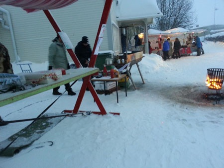 Một vài gian hàng nhỏ bày bán thức ăn đặt bên ngoài. Một bếp lửa đỏ rực đã làm tan giá ở góc chợ