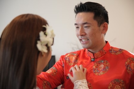 Cô dâu và chú rể trìu mến chỉnh sửa phục trang cho nhau