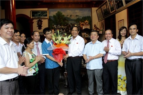 Hà Tĩnh: 2 học sinh vào đội tuyển dự thi Olympic Toán quốc tế - 1 Đại diện lãnh đạo tỉnh Hà Tĩnh tặng hoa chúc mừng em Võ Anh Đức. (Ảnh: BHT)