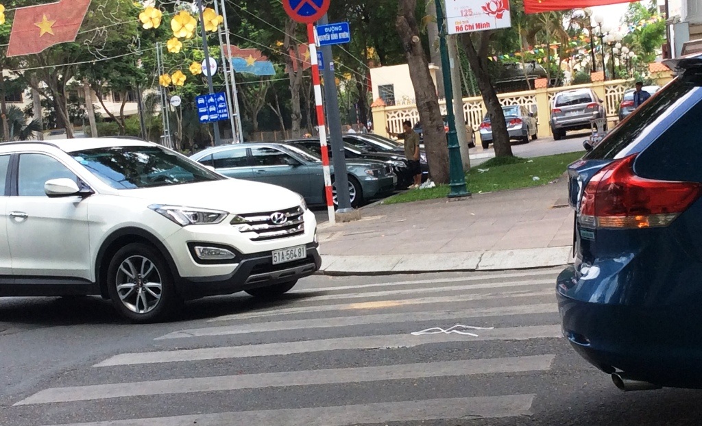 Đua nhau “cát cứ” đường phố, “trấn lột” tiền đậu xe ô tô - 1 Người đàn ông hướng dẫn xe đậu dưới lòng đường…