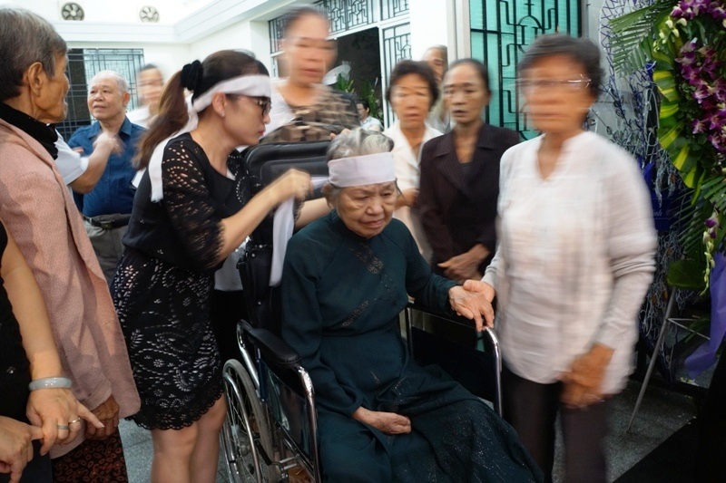 Vợ nhạc sĩ Phan Huỳnh Điểu ngồi xe lăn lặng khóc tiễn đưa chồng - 2 Khi các con mang khăn tang, bà vẫn im lặng không có
phản ứng gì