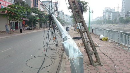Cột điện đổ ngang đường, dòng xe leo vỉa hè “thoát thân” - 2 2 cột điện khác và một cột đèn chiếu sáng cũng đổ nghiêng theo.