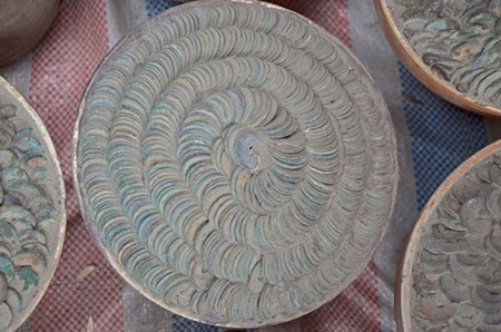 Những chum tiền phủ đầy bụi, dính đầy đất, tiền được xếp thành hình xoắn ốc một cách cẩn thận.