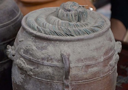 Những chum tiền phủ đầy bụi, dính đầy đất, tiền được xếp thành hình xoắn ốc một cách cẩn thận.