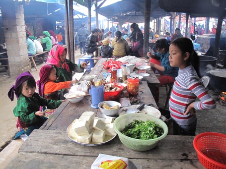 Đi chợ mua đồ đã xong, lũ trẻ nhỏ được mẹ cho ăn phở nóng – món ăn của người miền xuôi đem đến bán.