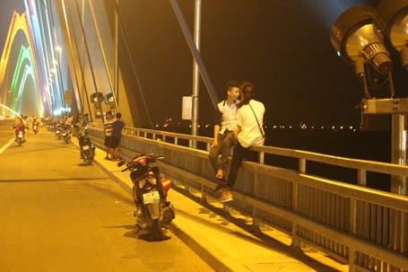 Đu lan can cầu hóng gió, bất chấp nguy hiểm.