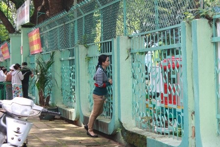 Phụ huynh đã tiếp cận được hàng rào trường, yên tâm hơn vì con cháu bên trong vẫn an toàn.