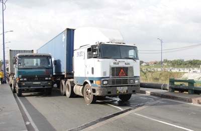 Chiếc container chắn giữa cầu khiến các xe tải khác phải nhích lên từng chút một.