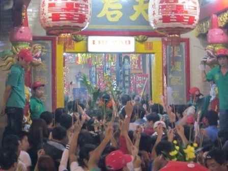 Trên tay cầm một nén nhang giơ cao, dòng người đông đúc chen chân vào chánh điện