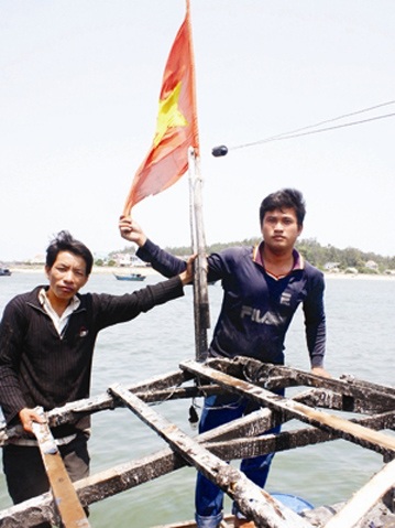 Tàu cá vừa bị Trung Quốc bắn nhổ neo ra Hoàng Sa - 2 Anh Thạnh và anh Phải bên lá cờ Tổ quốc. Ảnh: Nguyễn Thành.