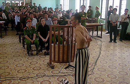 Được kháng nghị hủy án sau 14 năm thụ án chung thân - 1 Bị cáo Huỳnh Văn Nén cởi áo tại phiên tòa sơ thẩm, tố cáo bị điều tra viên dùng nhục hình. Ảnh: PN