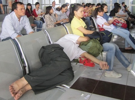 Nhiều hành khách chờ lấy vé mệt mỏi, nằm ngủ luôn tại nhà ga