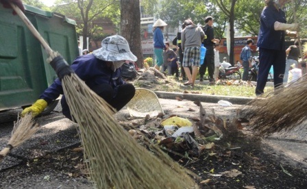 Màu áo xanh của các anh chị công nhân vệ sinh lại xuất hiện, tỉ mẩn nhặt nhạnh từng mẩu rác