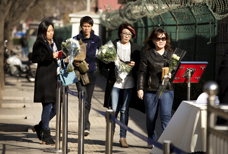 Một người phụ nữ khóc ngất khi đặt hoa tưởng niệm nhà lãnh đạo tài ba. (Ảnh: