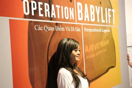 Một người phụ nữ chụp cùng một tấm poster trong triển lãm.