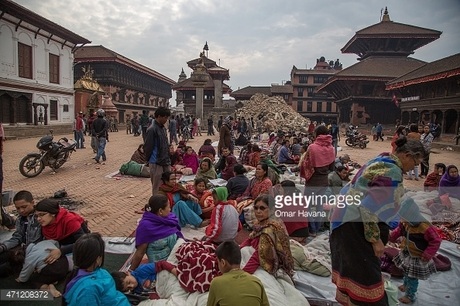 Nepal: Người dân đổ ra đường sau động đất, biến thủ đô thành khu trại lều - 9 Một người dân Nepal ngồi nghe điện thoại trong một lều trại ngoài trời tại thủ đô. (Ảnh: