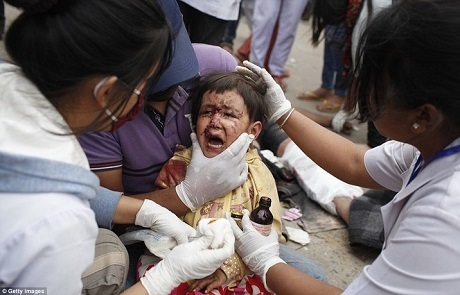 Đội cứu hộ đang khám cho một em bé bị thương sau trận động đất. (Ảnh: