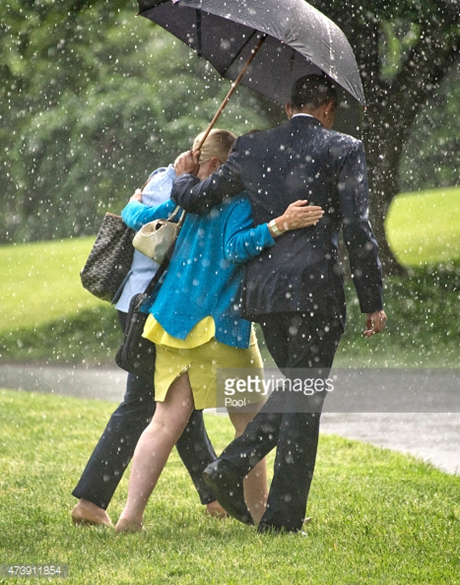 Tổng thống Obama lịch thiệp che ô cho hai nữ chính trị gia đi qua bãi cỏ phía nam Nhà Trắng.