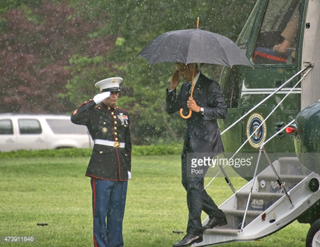 Tổng thống Obama giơ tay chào lại người lính gác khi bước xuống trực thăng Marine One.