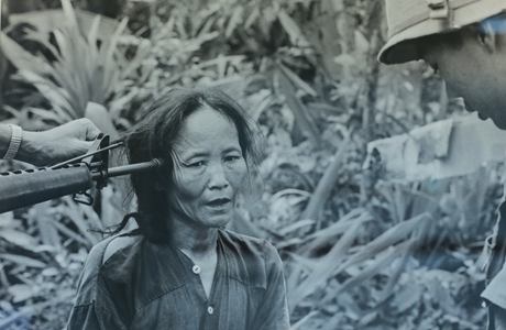 Một người phụ nữ Việt Nam bị kề súng vào đầu. 