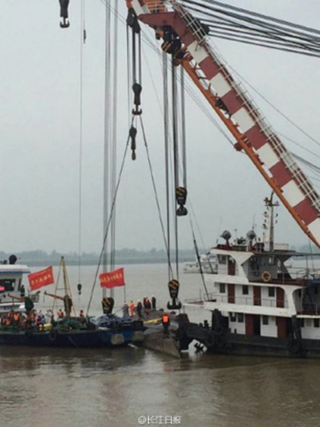 Đội cứu hộ bắt đầu lật tàu chìm với các cần trục. (Ảnh: 