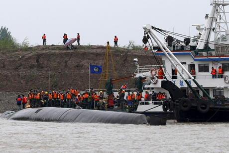 Trời mưa và lòng sông nhiều bùn gây khó khăn cho đội cứu hộ. (Ảnh: