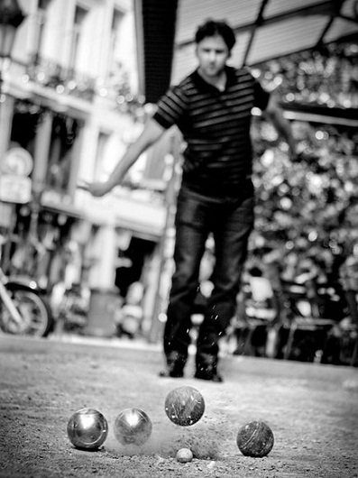Một người đàn ông đang chơi trò ném bi truyền thống trên đường phố Brussels, Bỉ.