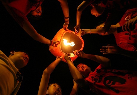 Người Châu Á rộn ràng đón Tết - 9 Những em bé người Indonesia gốc Hoa cùng nhau thả một chiếc đèn trời vào đêm giao thừa.