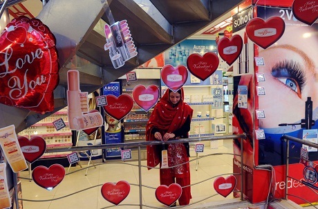 Một người bán hàng dạo với chùm bóng bay hình trái tim trên đường phố Bắc Kinh.