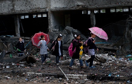Một em bé người Syria bị đạn lạc găm vào bàn tay, em được đưa tới bệnh viện dã chiến để phẫu thuật.