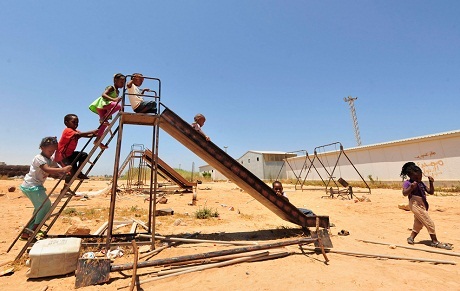 Trẻ em chơi đùa trên cầu trượt ở một trại tị nạn nằm trong thành phố Benghazi, Libya.