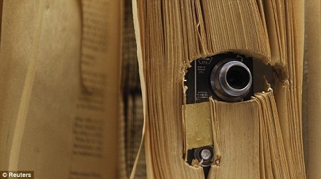 Một chiếc máy ảnh được đặt trong một cuốn sách bị khoét rỗng.