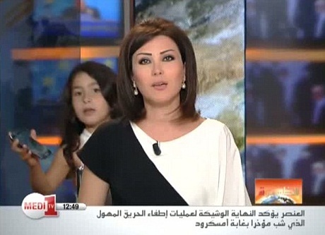 Sự cố "ngoài tưởng tượng" của truyền hình Morocco - 5 Cô bé vô tư bước lại gần mẹ và đưa điện thoại cho mẹ.