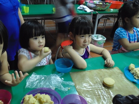 Các cô bé háo hức chờ được đưa bánh vào lò nướng.