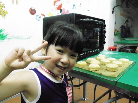 Cô bé với háo hức với mẻ bánh đầu tiên ra lò.