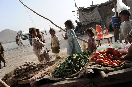 Nhìn để thấy sự khủng khiếp của đói nghèo - 15 Một bé gái người Afghanistan thích thú khi được tặng chiếc kẹo mút.