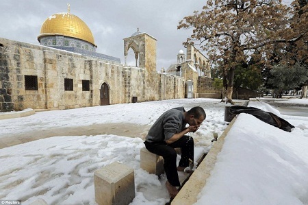 Hình ảnh thánh địa Jerusalem bất ngờ có tuyết sau 60 năm - 5 Một người đàn ông chuẩn bị hành lễ tại đền Mount.