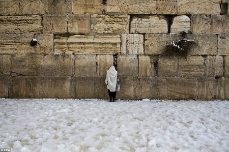 Hình ảnh thánh địa Jerusalem bất ngờ có tuyết sau 60 năm - 13 Những tín đồ cầu nguyện bên Bức tường Than khóc, xung quanh cô là mênh mông tuyết trắng.