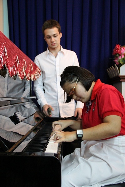 Mikhail Samasky lắng nghe tiếng đàn của một em học sinh khiếm thị.