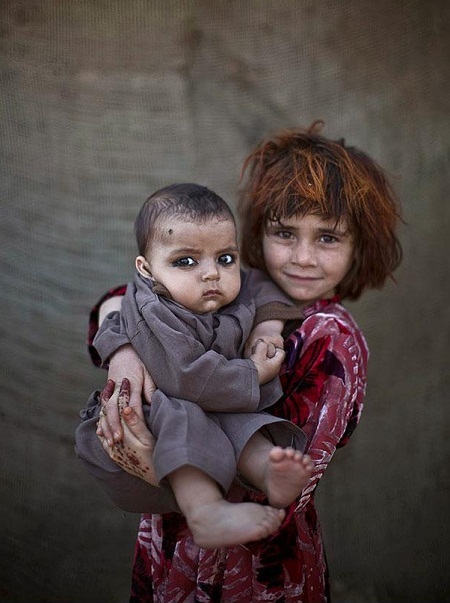 Em Khalzarin Zirgul (bên phải, 6 tuổi) đang bế cậu em họ 3 tháng tuổi Zaman.