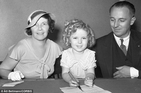Dấu mốc sự nghiệp đáng nhớ của "sao nhí" Mỹ vừa qua đời - 12 Cô bé Shirley Temple, 7 tuổi, cùng với cha mẹ ở bên, ký vào bản hợp đồng với công ty điện ảnh 20