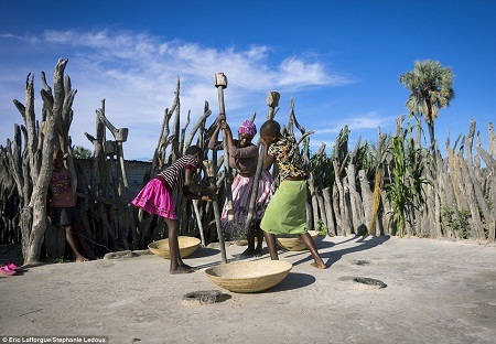 Phụ nữ trong bộ lạc cùng nhau giã gạo, một phần sẽ được mang tích vào kho thóc chung.