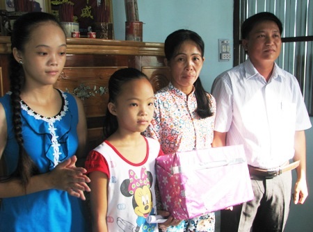 Đại diện chính quyền địa phương thị trấn Châu Hưng tặng quà cho 3 mẹ con chị Ngọc.