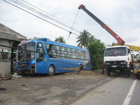 Xe khách tông gãy cột điện, lao vào nhà dân - 2 Cẩu xe khỏi hiện trường để làm nguyên nhân.