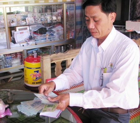 Đại diện địa phương kiểm đếm lại số tiền bạn đọc ủng hộ cho gia đình em Diễm.