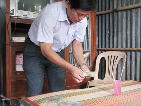 Đại diện địa phương kiểm đếm lại số tiền bạn đọc ủng hộ cho gia đình anh Sang.