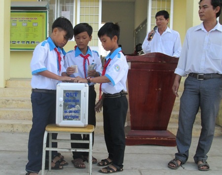 Học sinh cùng đóng góp vì bạn nghèo.