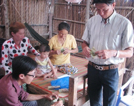 Đại diện chính quyền địa phương cùng gia đình cháu Nhân kiểm đếm lại số tiền bạn đọc hỗ trợ.